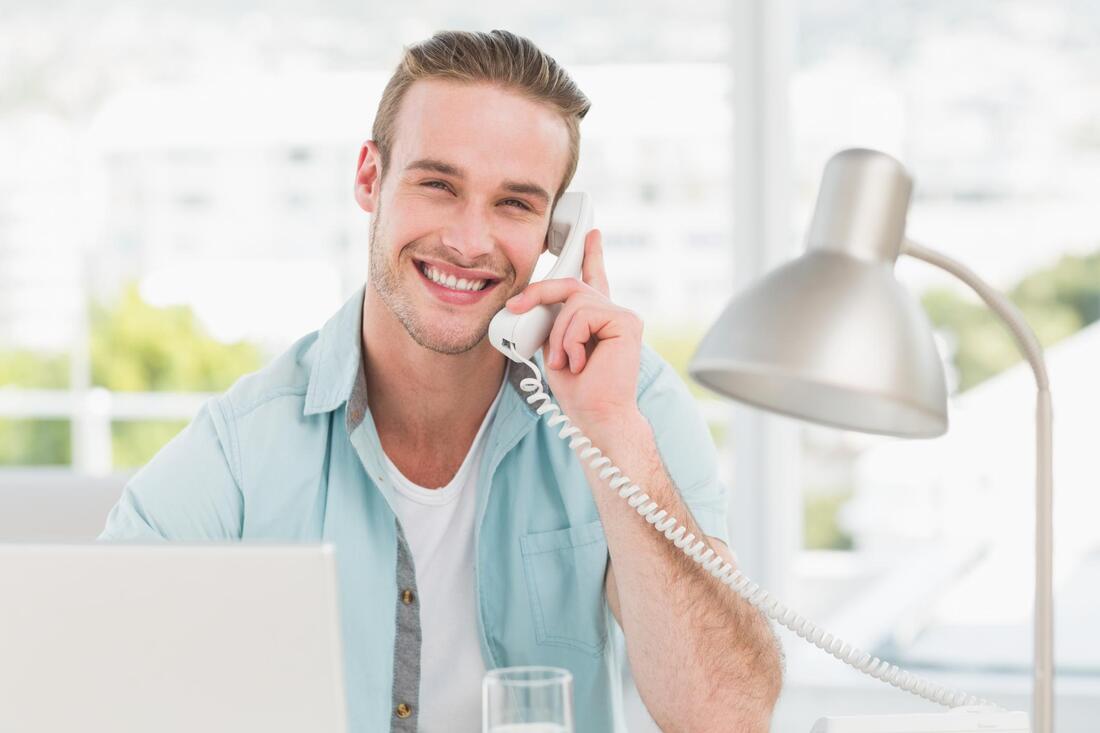 man holding a white telephone
